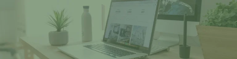 Open laptop displaying graphs on a desk with a plant, water bottle, and pen holder, all against the backdrop of a Melbourne Web Design office setup.