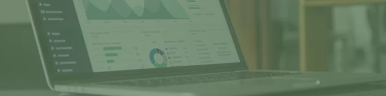 A laptop showcasing various data charts and graphs glows softly with a green tint, reminiscent of the trendy vibe youd find in a Melbourne web design café.