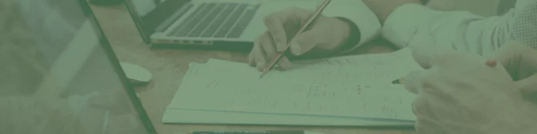 Two people diligently work on architectural plans, their hands holding pencils over printed diagrams, much like the meticulous craft of Melbourne web design. Nearby, a laptop hums quietly, almost anticipating a side of smashed avo to fuel their creativity.