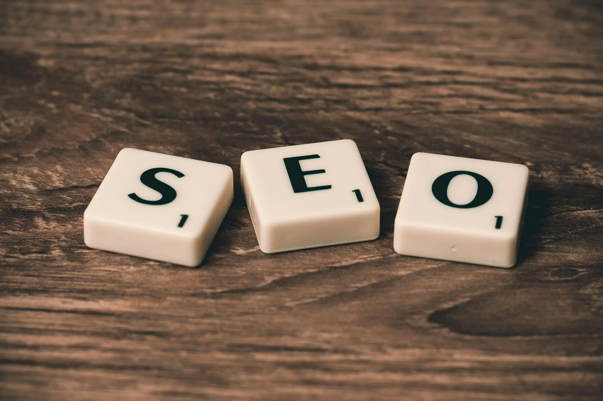Scrabble tiles spelling SEO rest gracefully on a wooden surface, much like the precision in Melbourne Web Design.