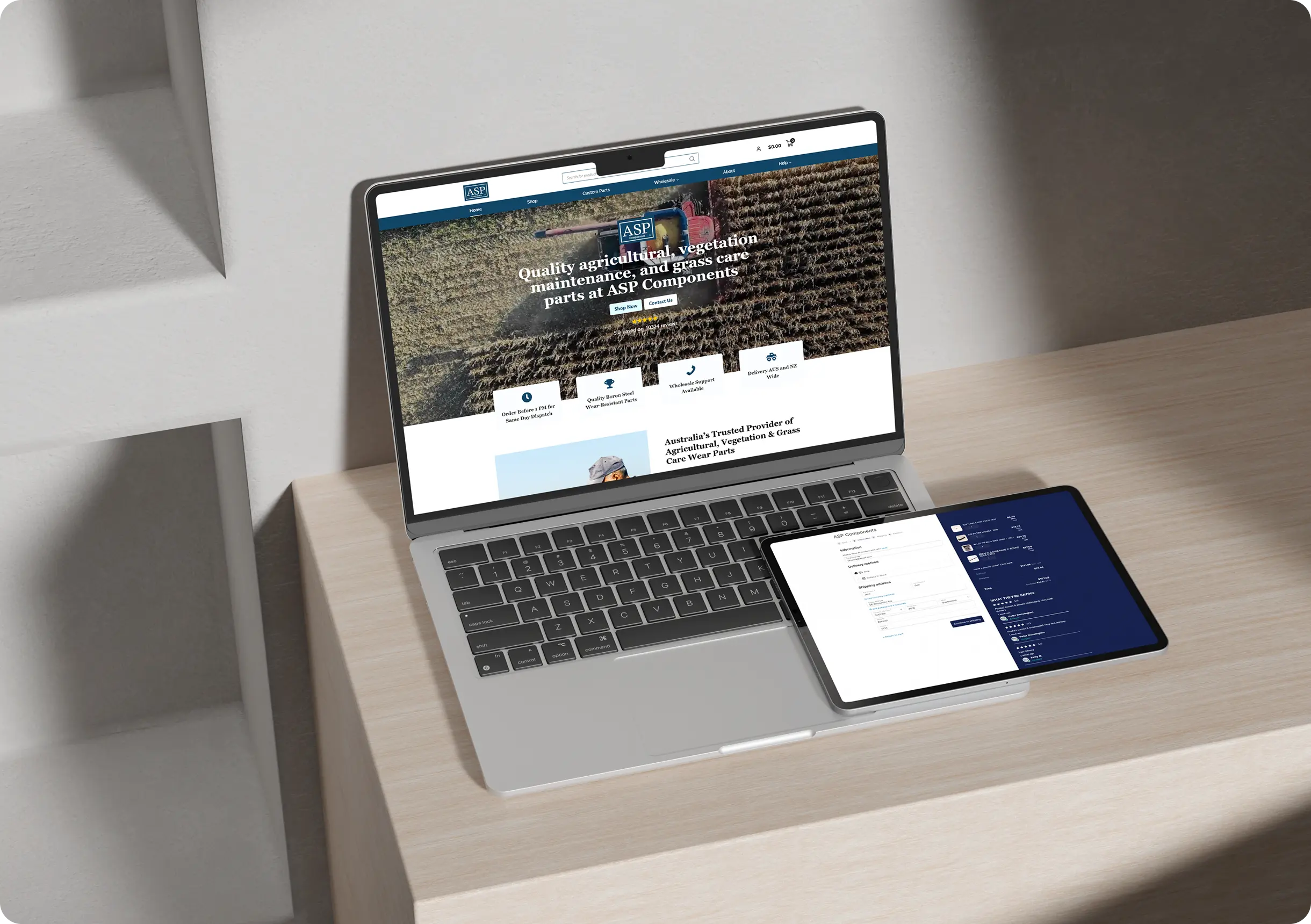 A laptop displaying an agricultural parts website sits on a light wood desk beside a tablet showing a list, with both devices turned on.
