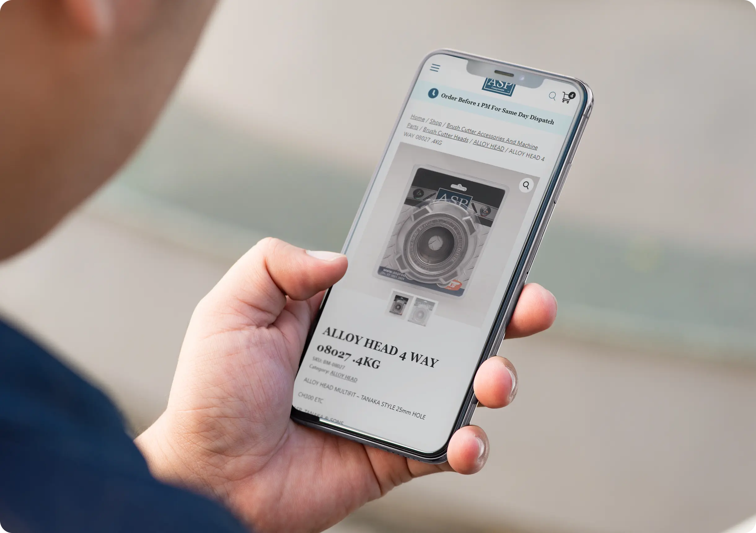 A person holds a smartphone displaying a product page for an alloy headway part labeled AGP 4KG on an online shopping website.